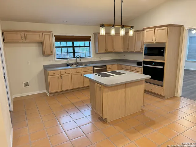 a kitchen with stainless steel appliances granite countertop a stove a sink and a refrigerator