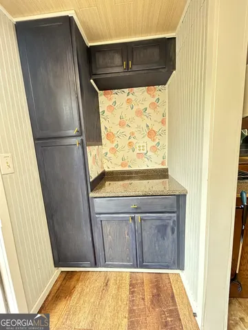 a living room with stainless steel appliances furniture a refrigerator and a sink