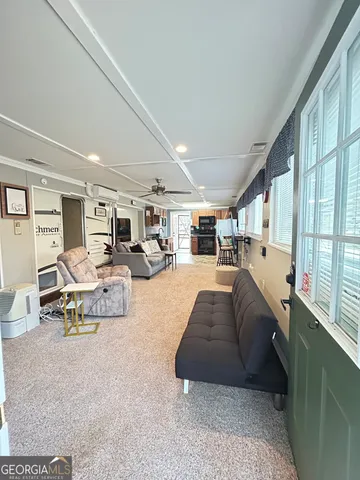 a view of a hallway and a livingroom with furniture
