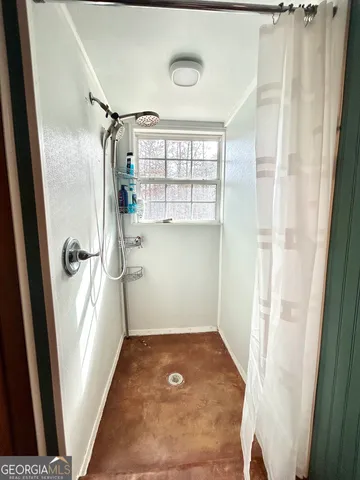 a bathroom with a toilet and a painting on the wall