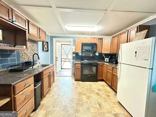 a kitchen with stainless steel appliances granite countertop a refrigerator a stove a sink a stove and a microwave