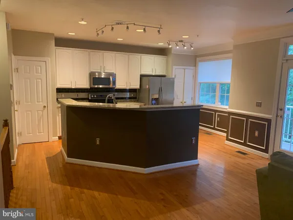 a kitchen with stainless steel appliances granite countertop a stove a sink a refrigerator and a microwave