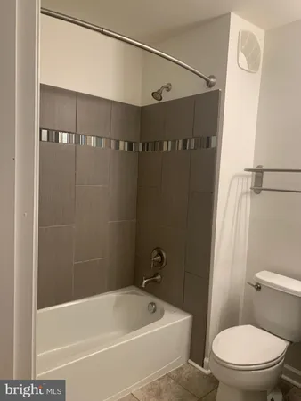 a white toilet sitting next to a bath tub