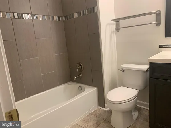 a white toilet sitting next to a bathtub