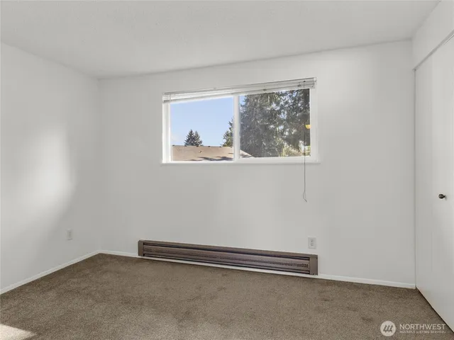 an empty room with a painting on the wall