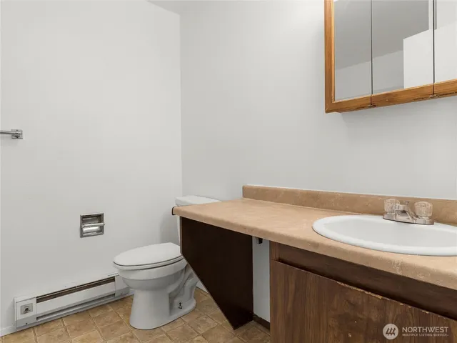a bathroom with a sink a toilet and a mirror