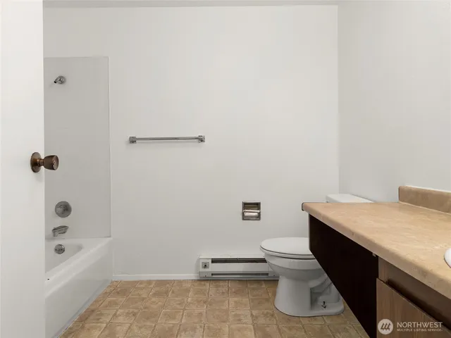 a bathroom with a granite countertop sink a toilet and shower