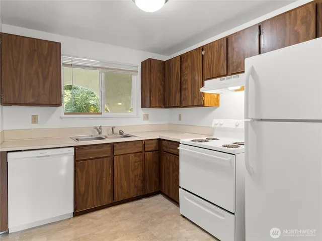 a kitchen with a refrigerator sink and cabinets