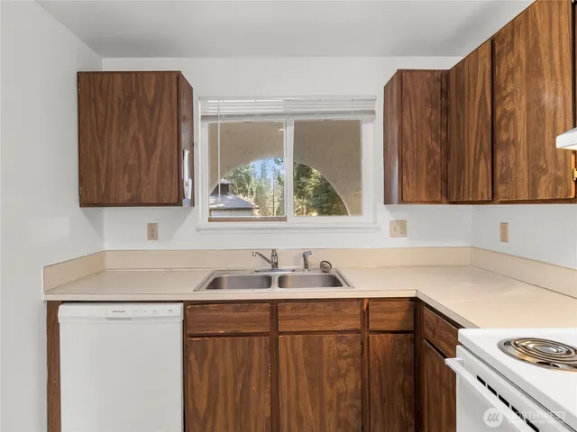 a kitchen with a sink cabinets and a window