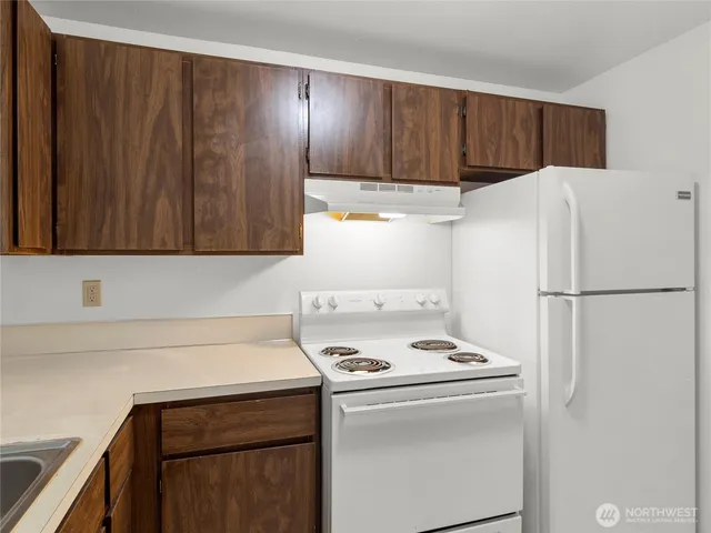 a kitchen with refrigerator and a stove