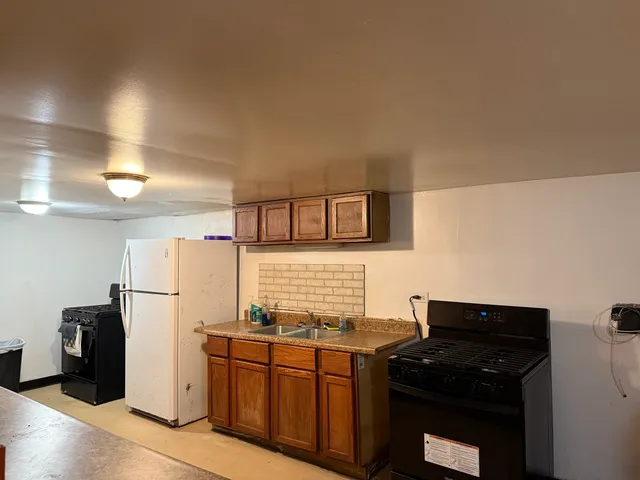a kitchen with stainless steel appliances granite countertop a refrigerator and a stove top oven