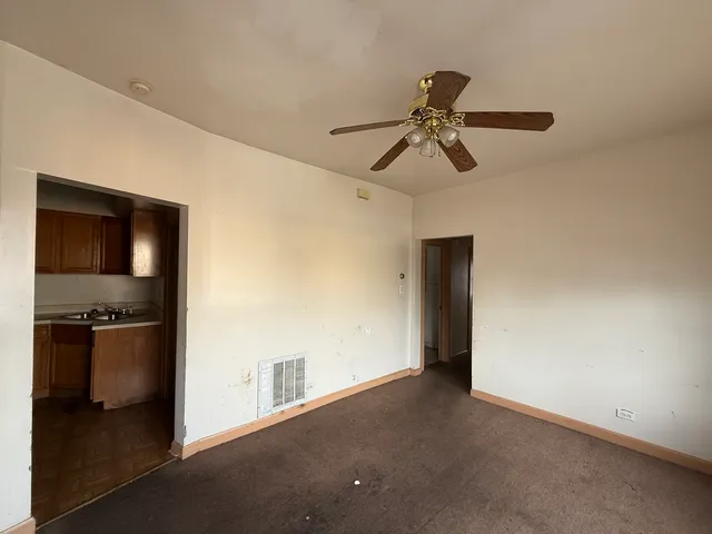 a view of a livingroom with a ceiling fan and entryway