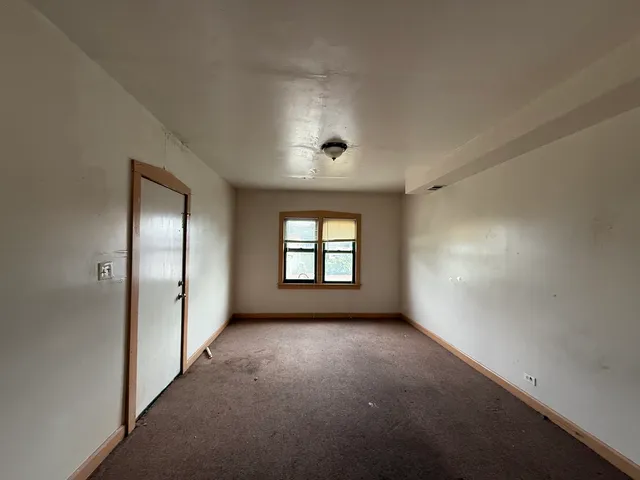 a view of a house with a small yard and wooden fence