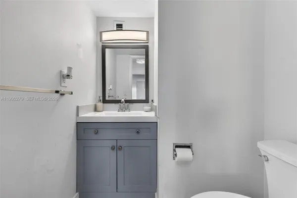 a bathroom with a toilet a sink and mirror