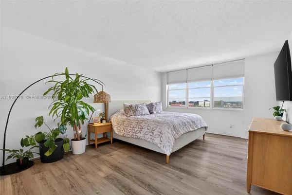 a bedroom with a bed and a potted plant