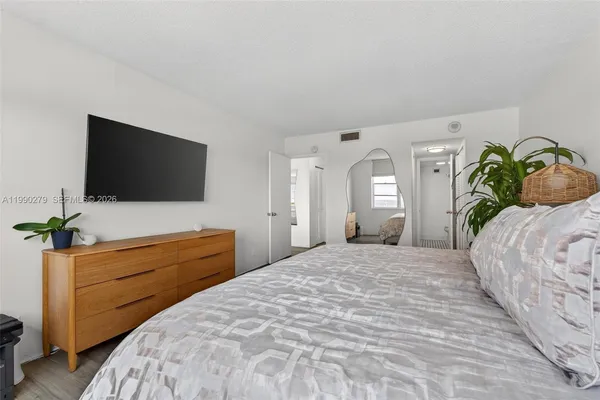 a bedroom with a bed and a flat screen tv