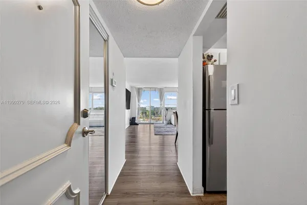 a view of a hallway with wooden floor and staircase