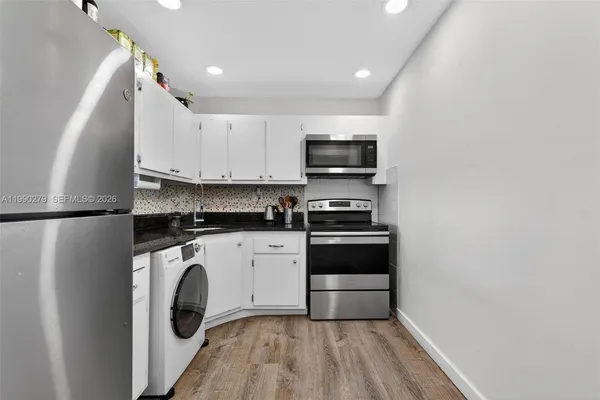a kitchen with a refrigerator and a stove top oven