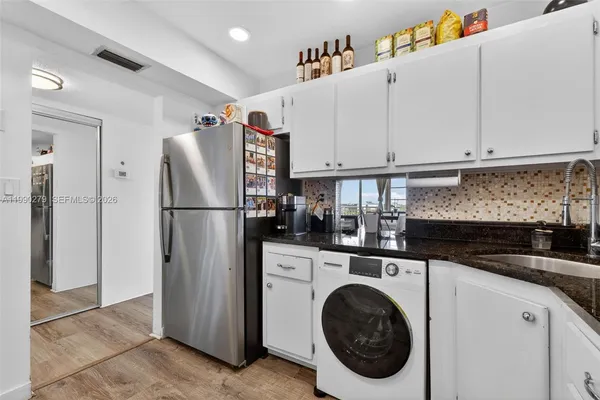 a kitchen with refrigerator and cabinets