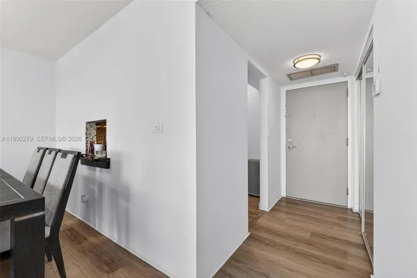 a view of a hallway with wooden floor and stairs