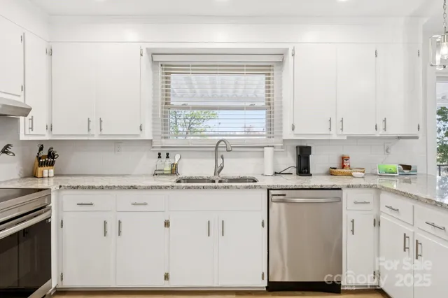 a kitchen with granite countertop white cabinets and white appliances