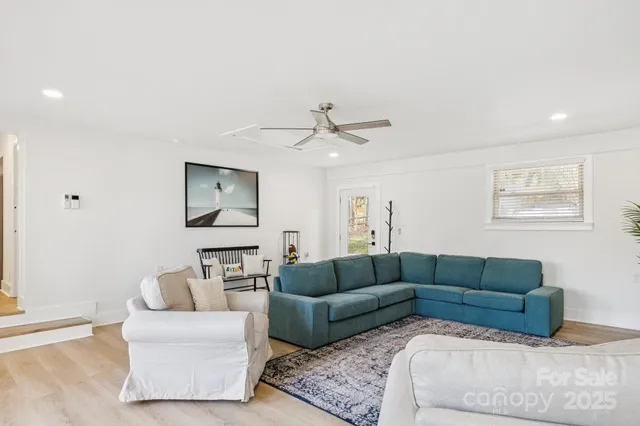 a living room with furniture and a ceiling fan