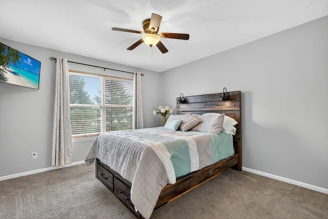 a bed sitting in a bedroom next to a window