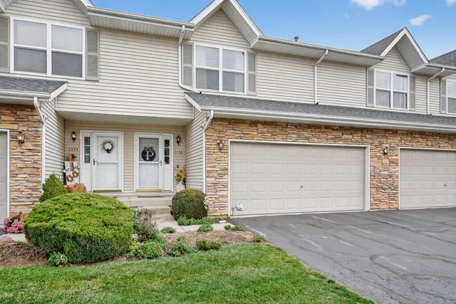 a front view of a house with a yard and garage