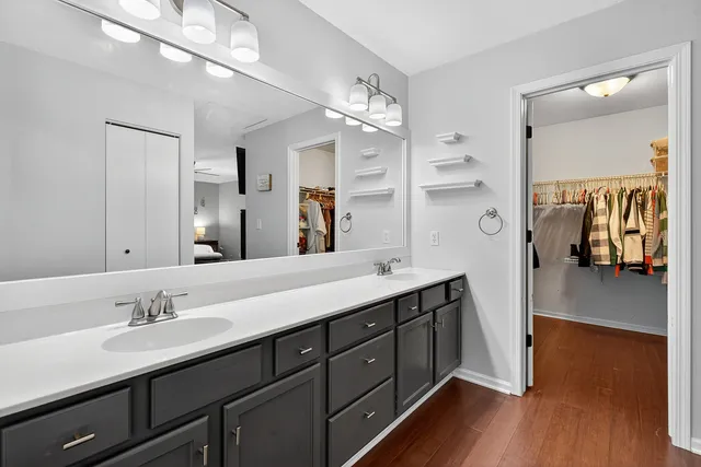 a spacious bathroom with a double vanity sink a mirror and shower