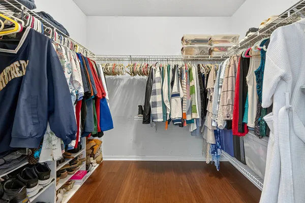 a view of walk in closet with clothes and shoes