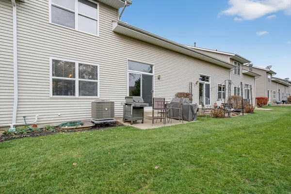 a backyard of a house with table and chairs
