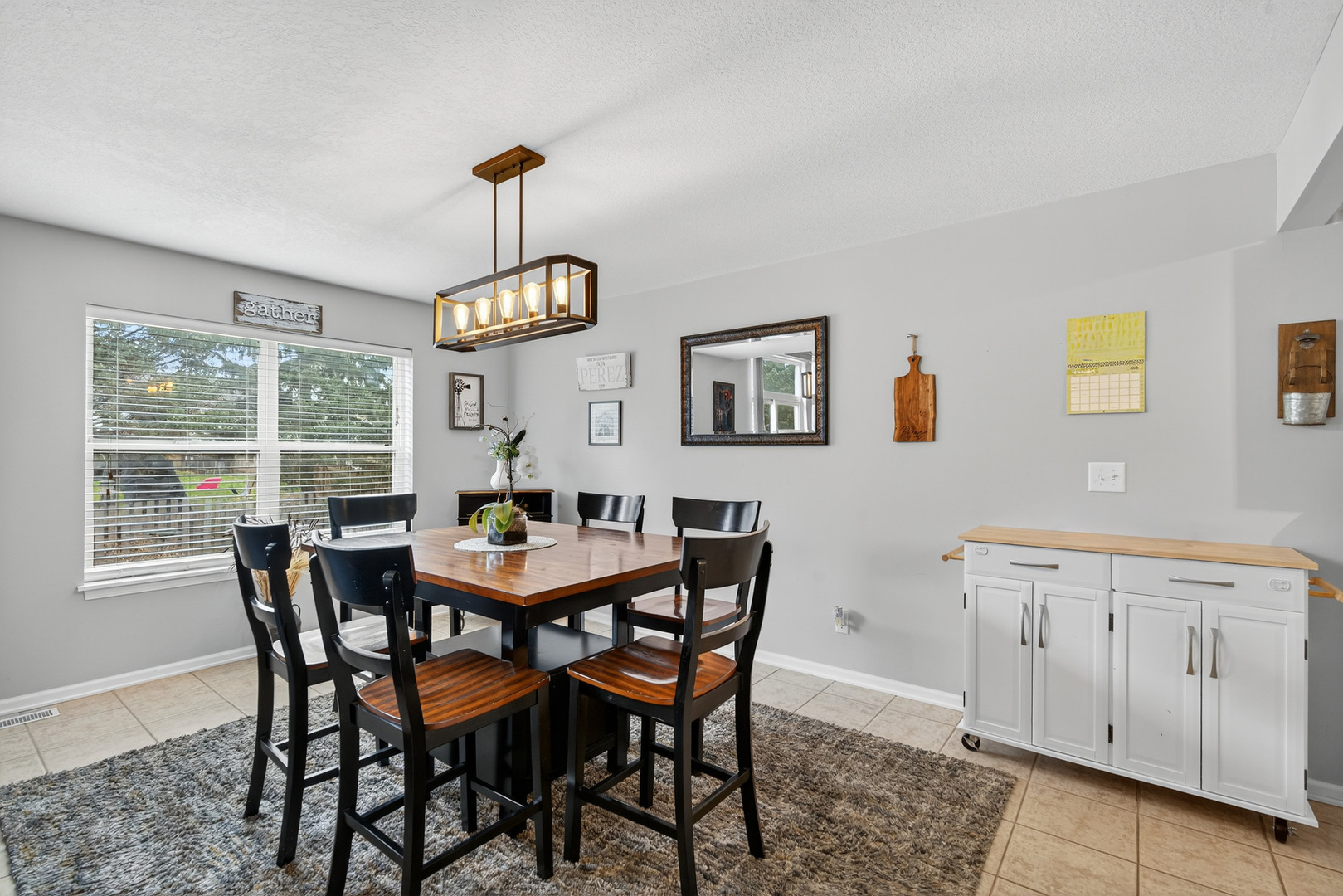 1152 Rose Drive Sycamore, IL 60178 - Photo 7 of 34 a dining room with wooden floor a chandelier a wooden table and chairs