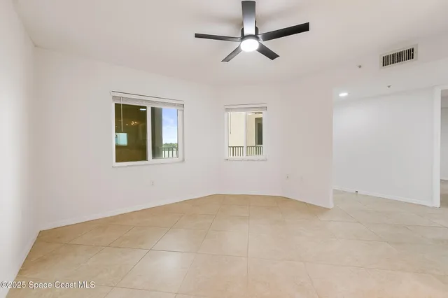 a view of a room with a chandelier fan and wooden floor