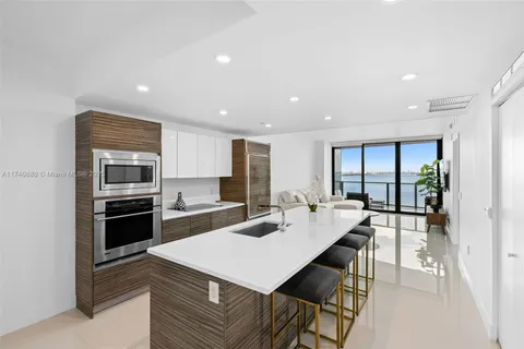 a large kitchen with stainless steel appliances a sink stove and cabinets