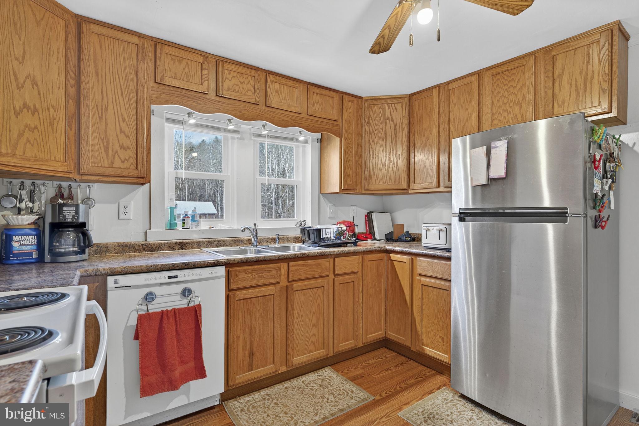 10500 Ford Hill Road Rio, WV 26755 - Photo 12 of 59 a kitchen with stainless steel appliances granite countertop a refrigerator a sink dishwasher a stove with wooden cabinets and floor