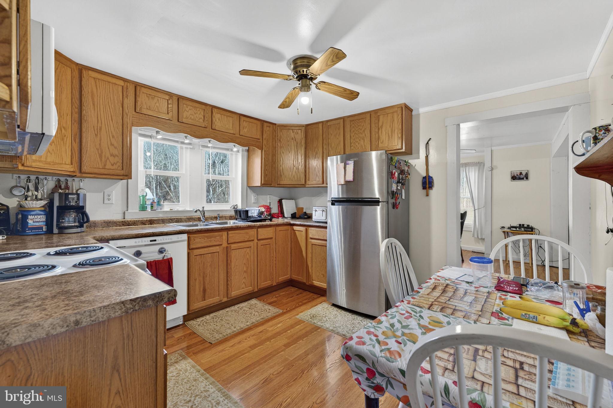 10500 Ford Hill Road Rio, WV 26755 - Photo 13 of 59 a kitchen with stainless steel appliances granite countertop a refrigerator a sink dishwasher a dining table and chairs with wooden floor