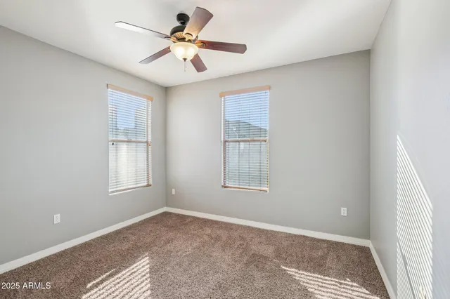 a view of a livingroom with a chandelier fan and wooden floor