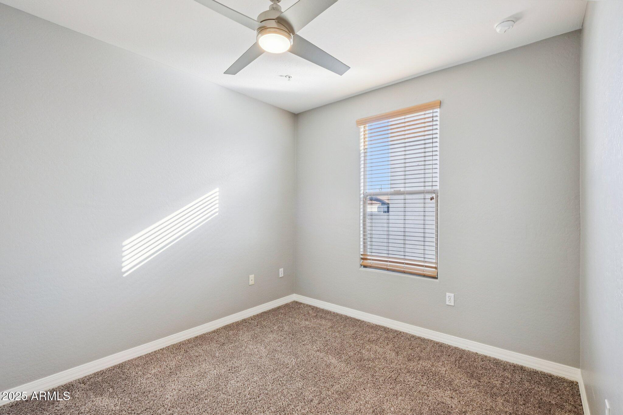 615 East Portland Street, Unit 115 Phoenix, AZ 85004 - Photo 13 of 32 an empty room with a window and chandelier fan