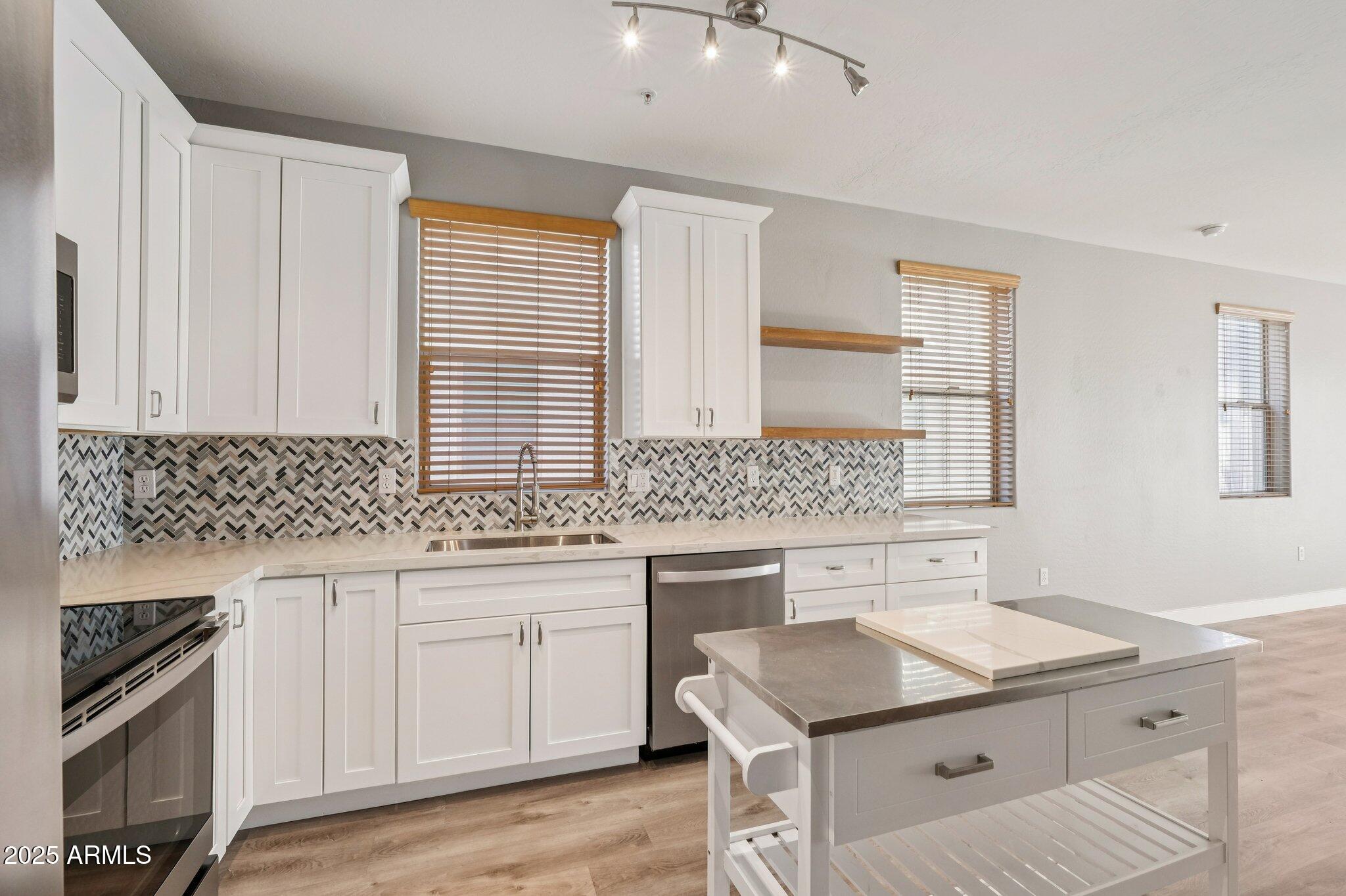 615 East Portland Street, Unit 115 Phoenix, AZ 85004 - Photo 2 of 32 a kitchen with a sink stove and cabinets