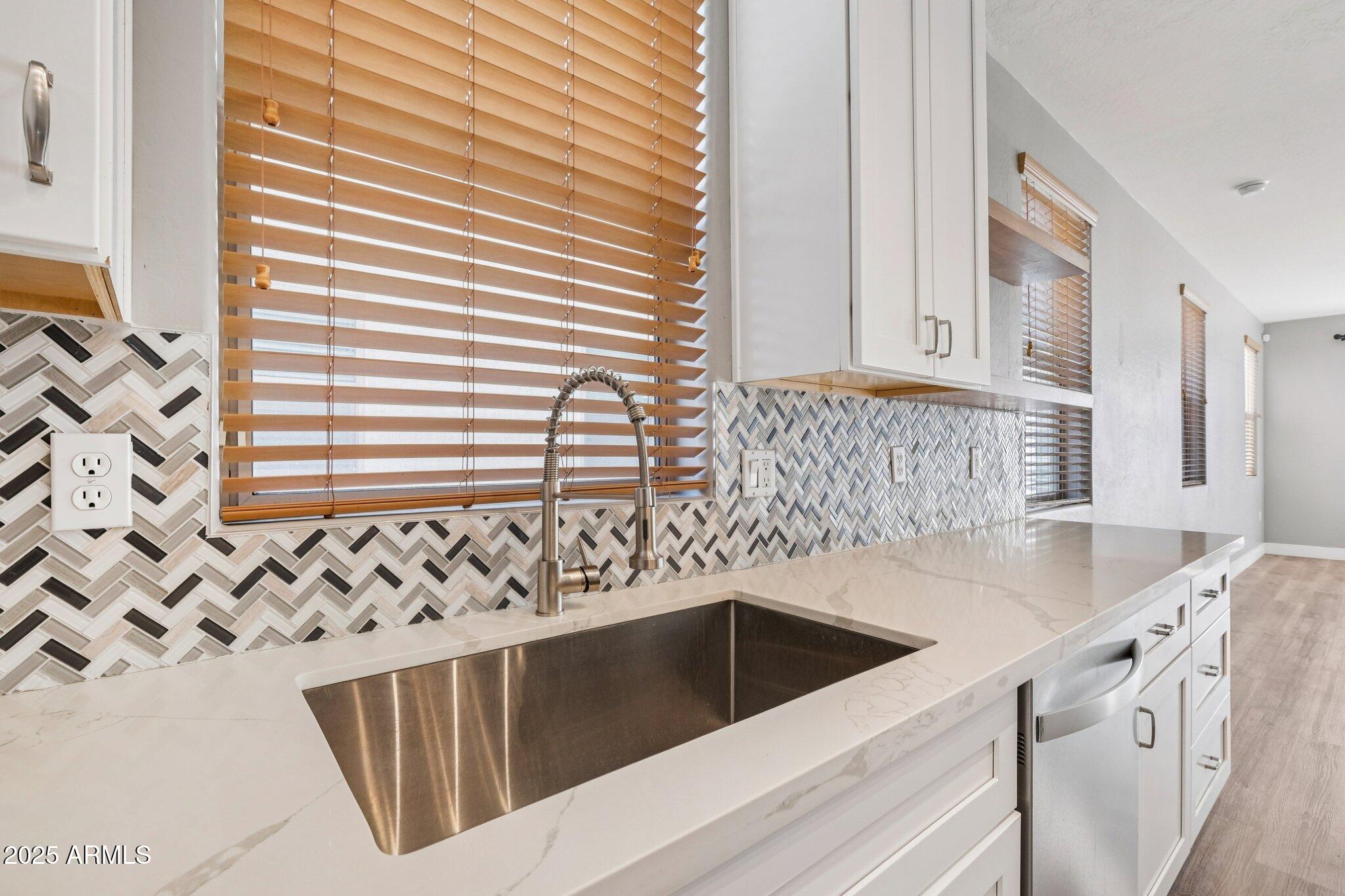 615 East Portland Street, Unit 115 Phoenix, AZ 85004 - Photo 3 of 32 a kitchen with granite countertop white cabinets and sink