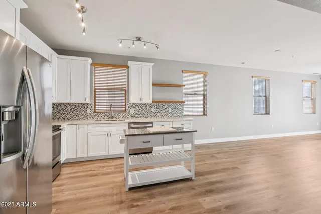 a kitchen with granite countertop white cabinets and sink