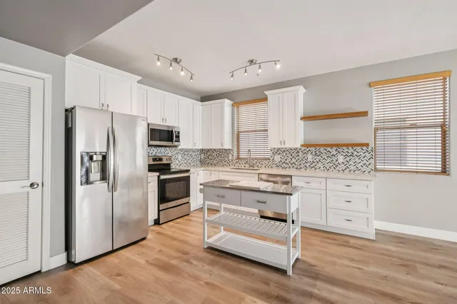 a kitchen with white cabinets and stainless steel appliances