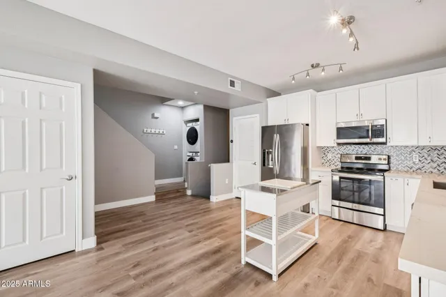 a kitchen with white cabinets and stainless steel appliances