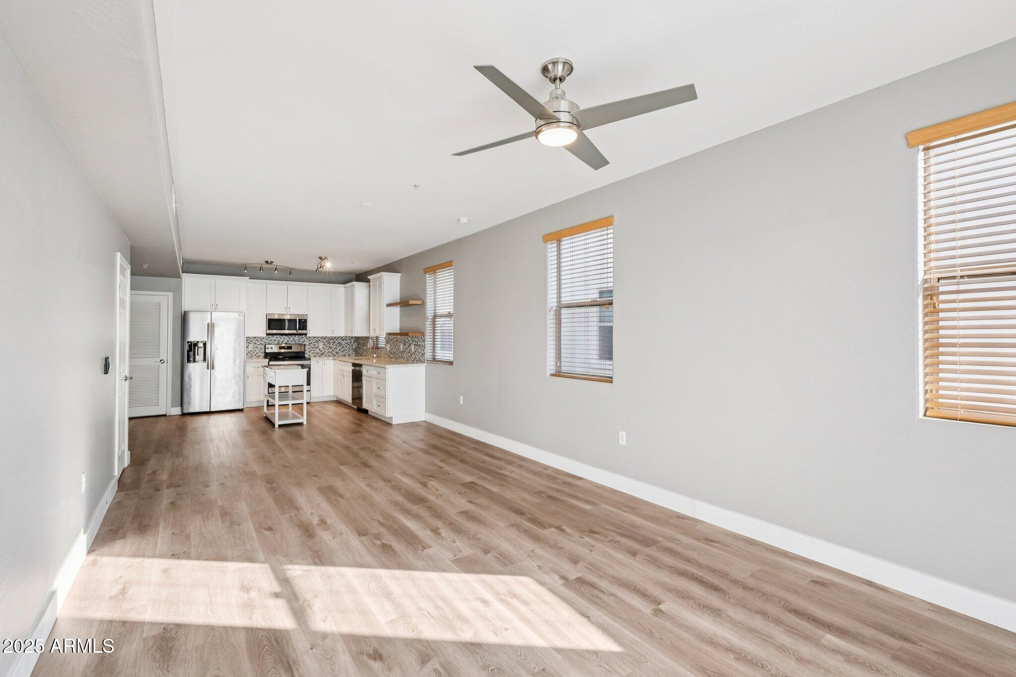 615 East Portland Street, Unit 115 Phoenix, AZ 85004 - Photo 8 of 32 a view of a livingroom with wooden floor a ceiling fan and windows