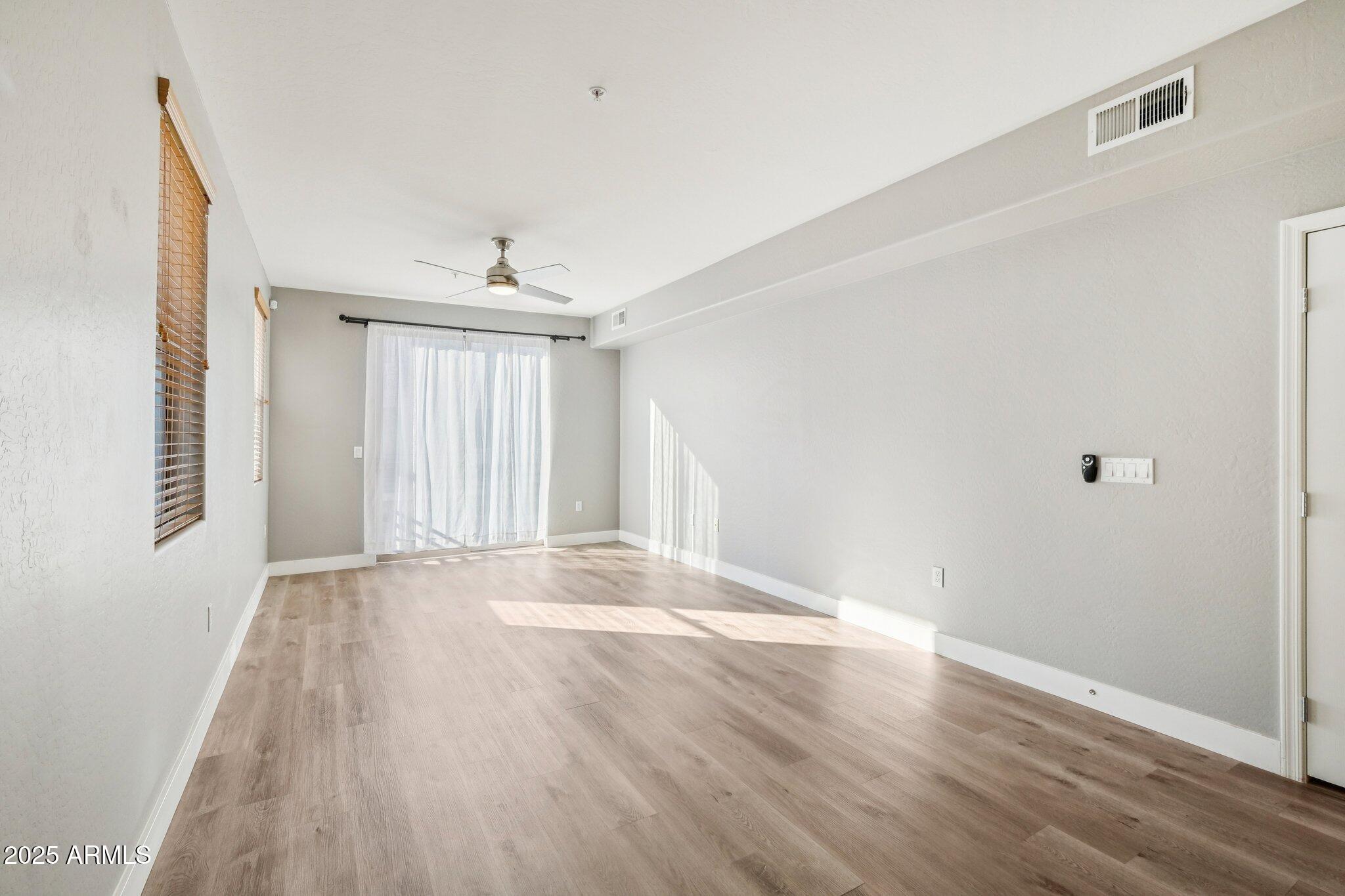 615 East Portland Street, Unit 115 Phoenix, AZ 85004 - Photo 9 of 32 a view of an empty room with wooden floor and a window