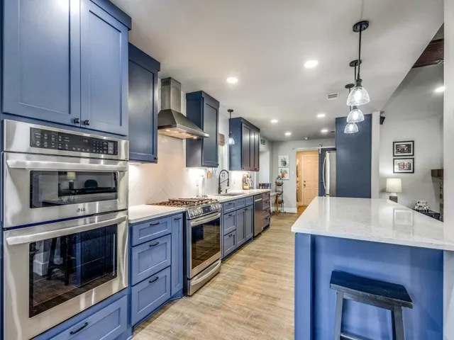 a kitchen with stainless steel appliances a stove a refrigerator and wooden cabinets