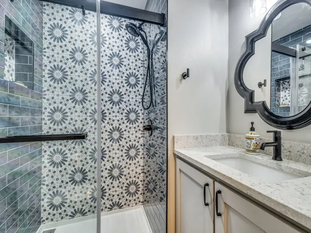 a bathroom with a granite countertop double vanity sink and a mirror