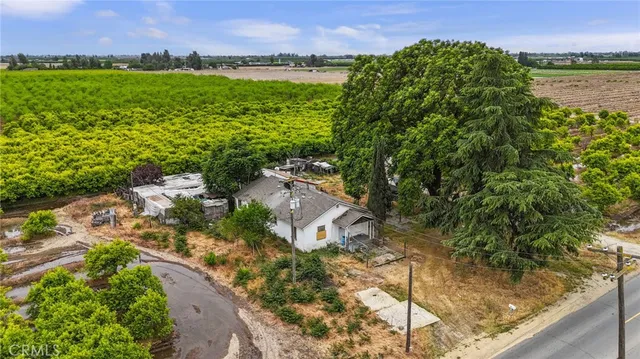 a view of a house with a yard and a large pool center with large trees