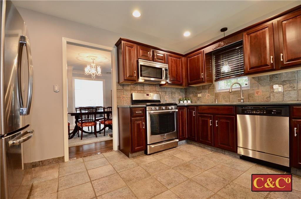 8 Oak Street Valley Stream, NY 11581 - Photo 9 of 40 a kitchen with stainless steel appliances granite countertop a stove a sink and a microwave