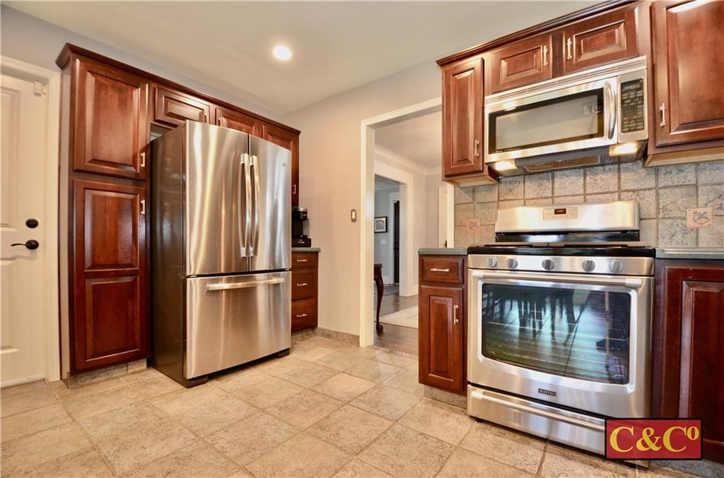 8 Oak Street Valley Stream, NY 11581 - Photo 10 of 40 a kitchen with granite countertop a refrigerator stove and microwave